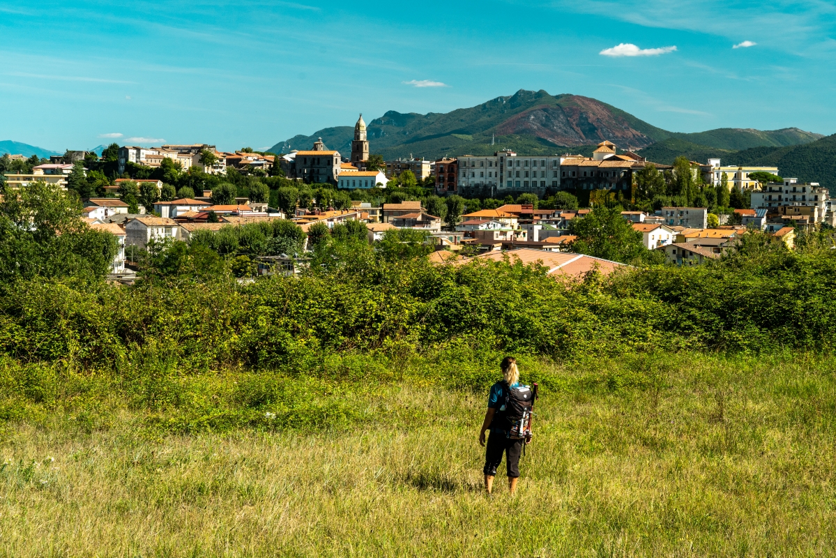 A pilgrim on the Via Francigena in front of the city of Teano - ENIT SpA