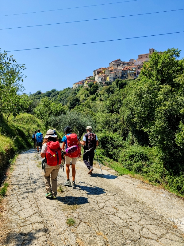 A group of pilgrims on the Via Francigena walks towards the village of Ponzano Superiore - ENIT SpA