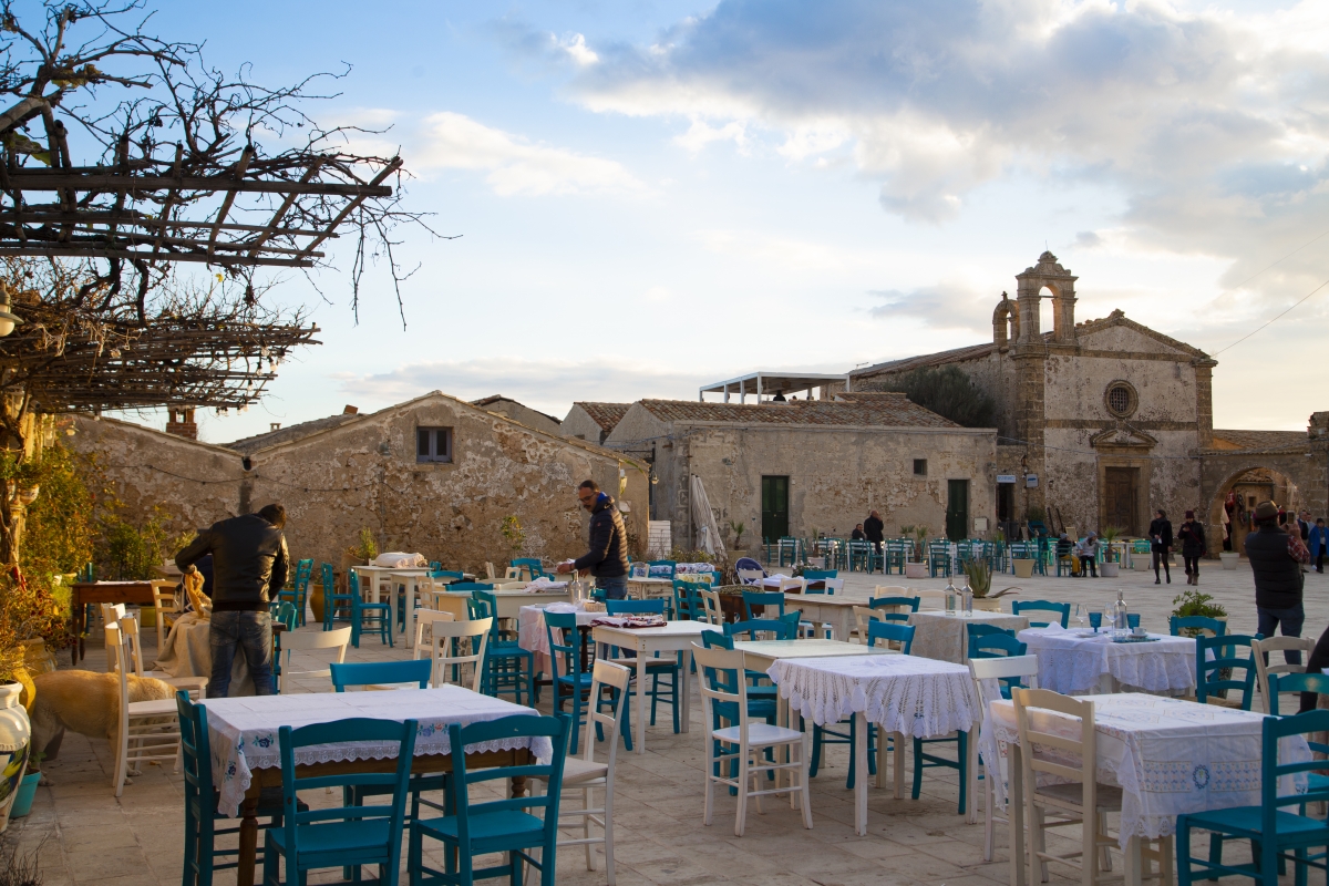Ristorante tipico a Marzamemi con la Chiesa di San Francesco Di Paola sullo sfondo - Simone Antonazzo / ENIT SpA