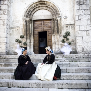 Due donne con indosso i costumi tradizionali di Scanno sulla gradinata della Chiesa di Santa Maria della Valle - ENIT SpA