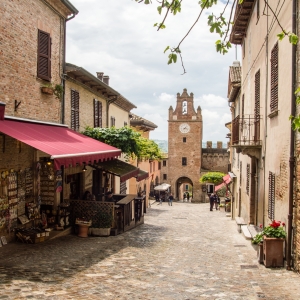 Gradara, via Umberto I; in fondo alla strada la Torre dell'Orologio - ENIT SpA