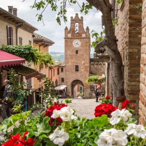 Gradara, via Umberto I; in fondo alla strada la Torre dell'Orologio - ENIT SpA