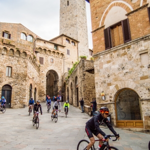 San Gimignano, ciclisti in piazza della Cisterna; sullo sfondo, la Torre dei Becci - ENIT SpA