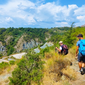 Due pellegrini sulla Via Francigena, sullo sfondo a destra il borgo di Ponzano Superiore - ENIT SpA